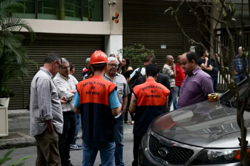 Agentes da Defesa Civil Municipal liberam duas pessoas por vez a entrar em suas lojas