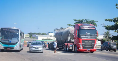 Pedestre tenta se arriscar entre os veículos para atravessar a estrada