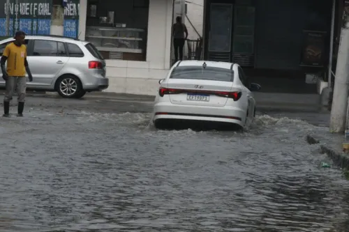 Carro passa por rua alagada em São Gonçalo