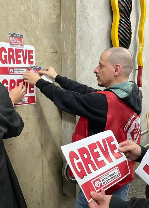 Grevistas colam cartazes para mobilização em São Paulo