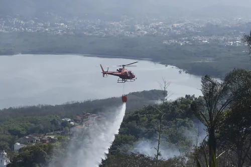 Helicóptero dos bombeiros combatendo focos de incêncdio