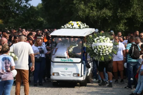 A mãe de Rhuan acompanhou o cortejo junto ao caixão, dentro do carrinho do cemitério