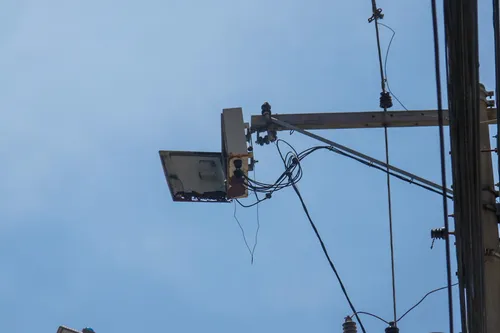 Na Rua Gavião Peixoto, uma caixa de metal está pendurada em um poste