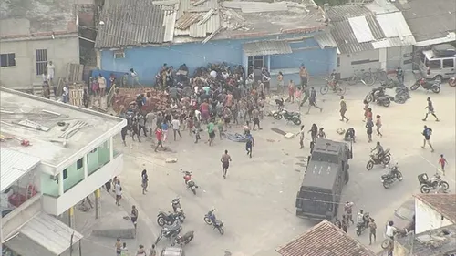 Moradores da comunidade avançam na carga de carne diante da PM