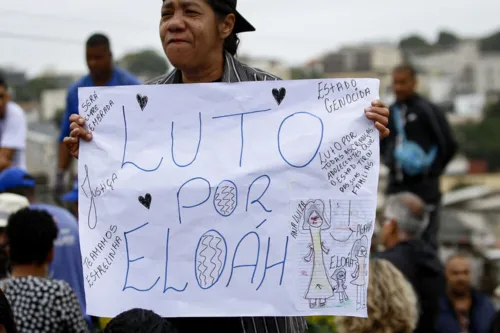 Mulher segura cartaz sobre a morte da menina: luto