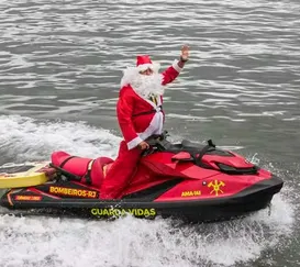 Papai Noel chega de moto aquática e surpreende crianças no Rio