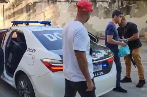 Iram (camisa azul) é conduzido por policiais