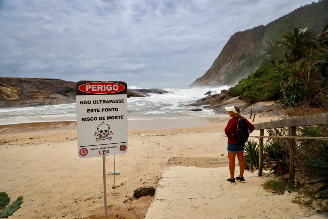 Curiosos se arriscam na beira de mar agitado em Itacoatiara