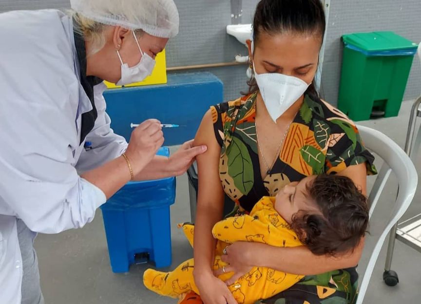 Fernanda tomando a vacina contra a Covid-19 com Catarina em seus braços