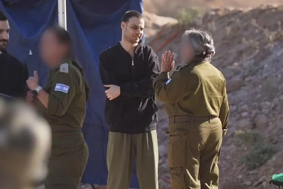 Refém libertado Alon Ohel com representantes das Forças de Defesa de Israel