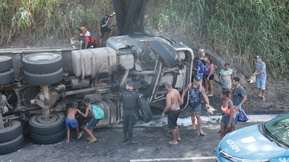 Moradores pegam carga de galinhas de caminhão que tombou na via 