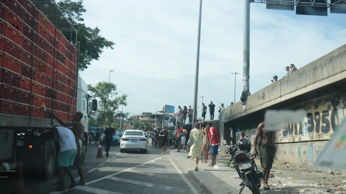 Moradores pegam carga de galinhas de caminhão que tombou na via 