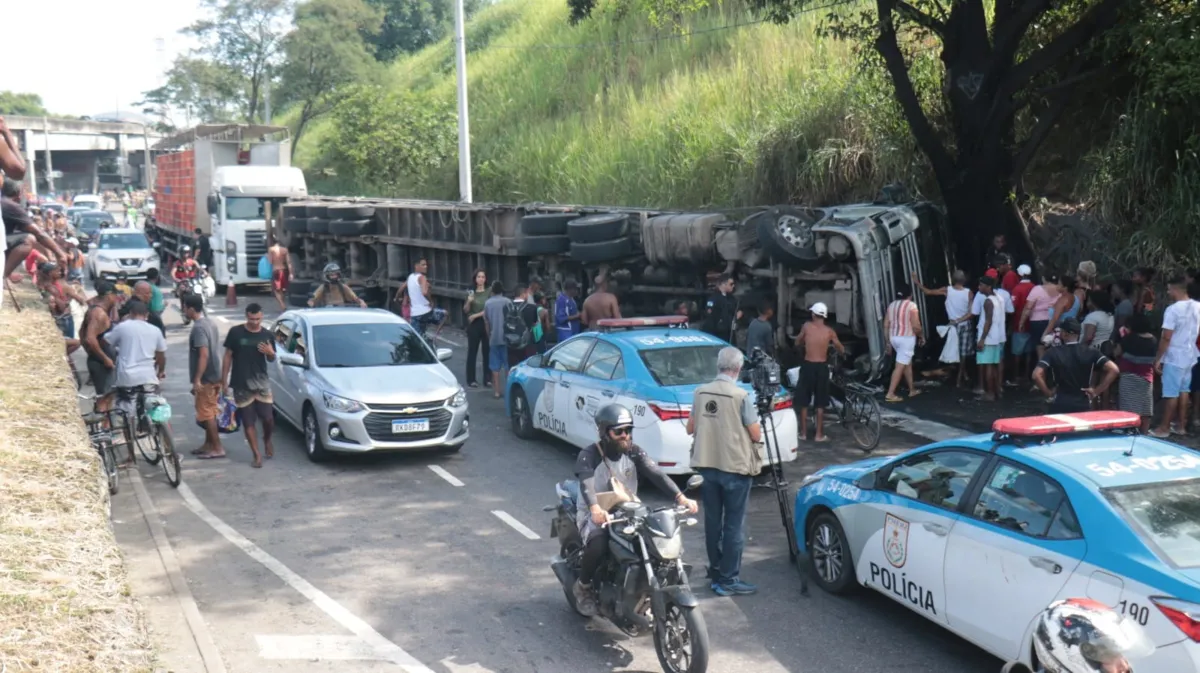 Moradores pegam carga de galinhas de caminhão que tombou na via 