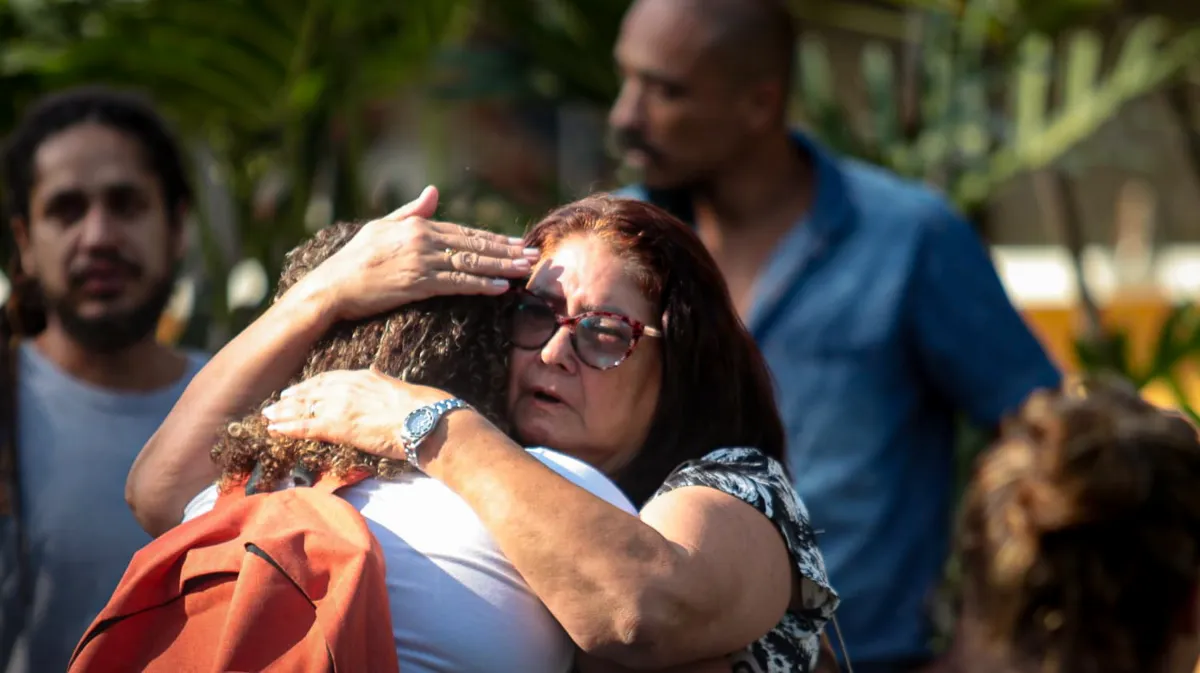 Parentes e amigos se abraçam durante cerimônia