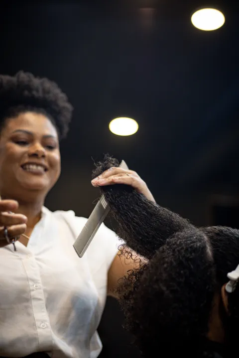 Lola cortou o cabelo de sua cliente e tirou as partes alisadas 