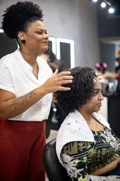 Lohane (sentada) após o big chop, com o cabelo com os cachos mais definidos 