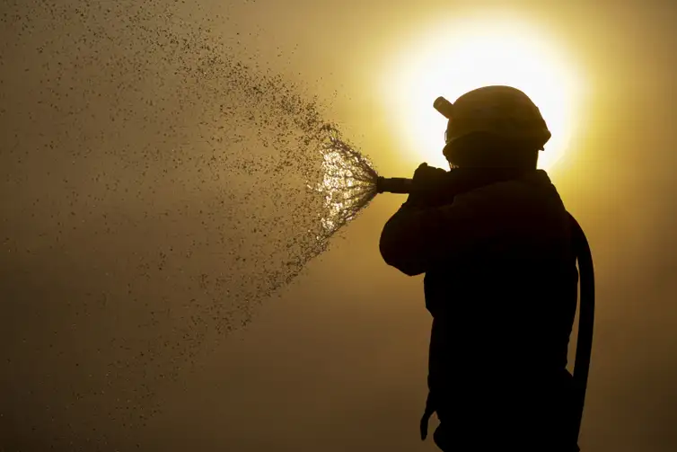 Brigadista faz resfriamento do fogo durante incêndio que atinge o Pantanal