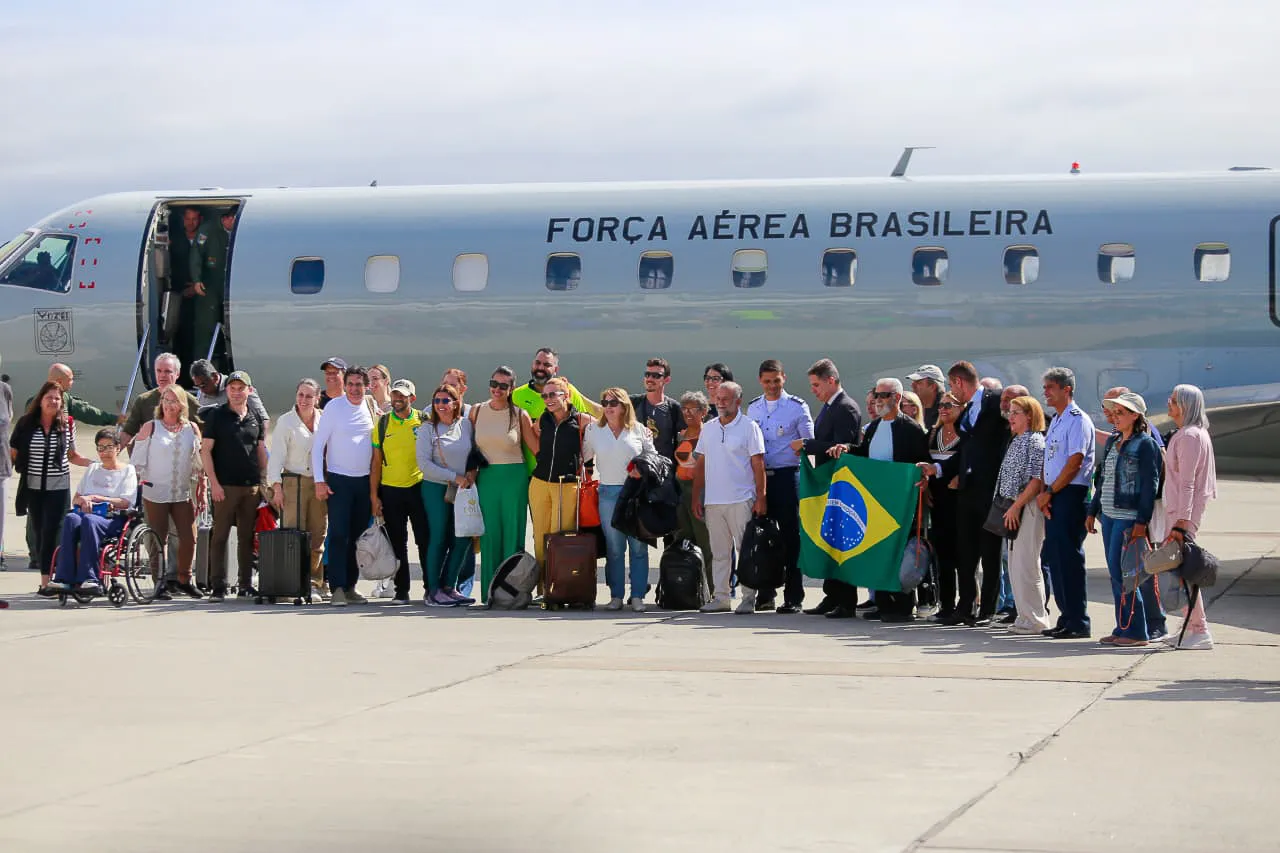 Brasileiro em frente ao avião da FAB na chegada ao Rio