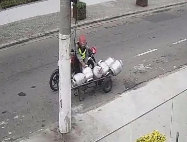 Câmera flagrou quando homem para com a moto e leva o botijão de gás