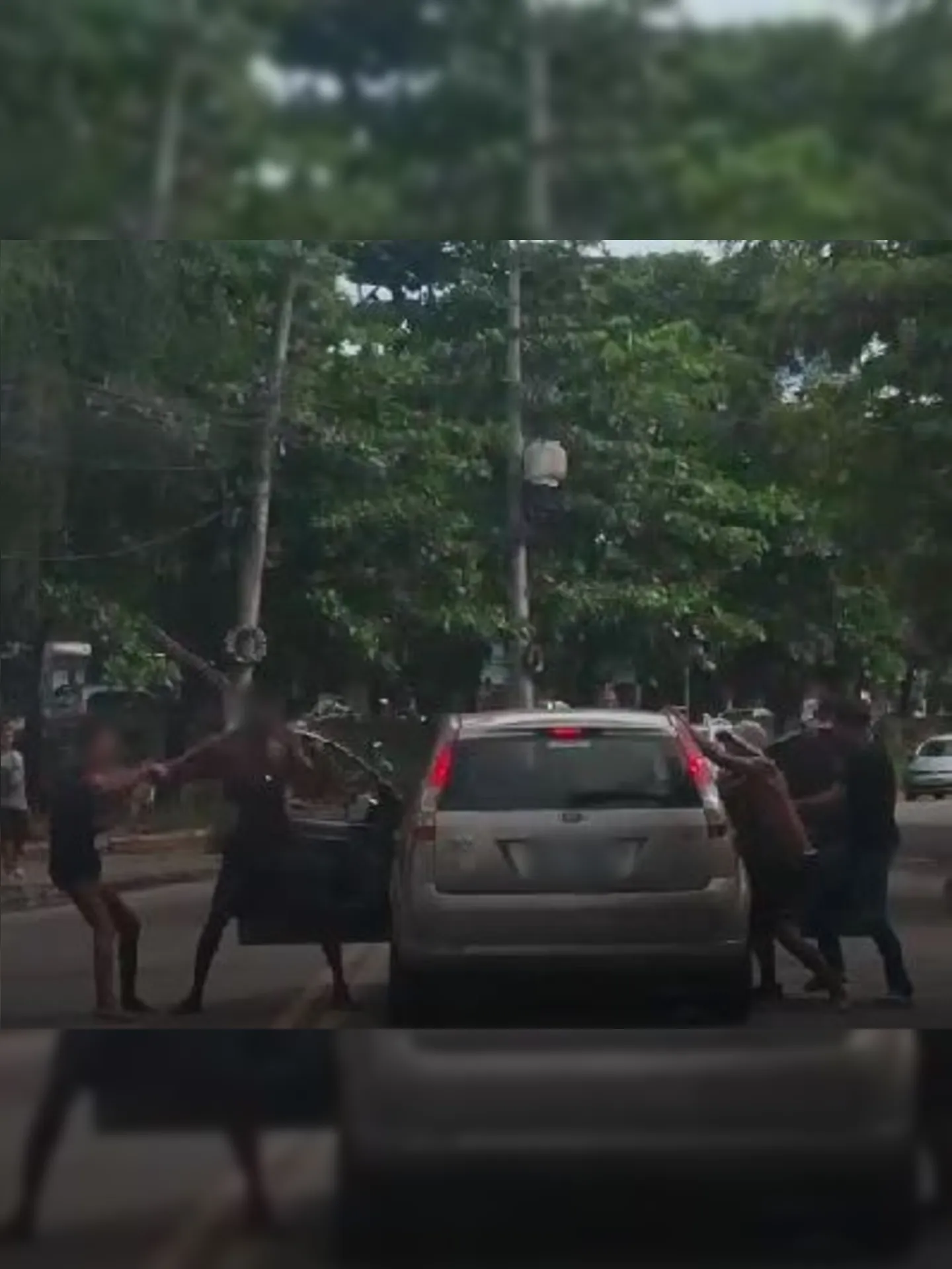 Nas imagens, é possível observar um homem sendo agredido dentro de um carro