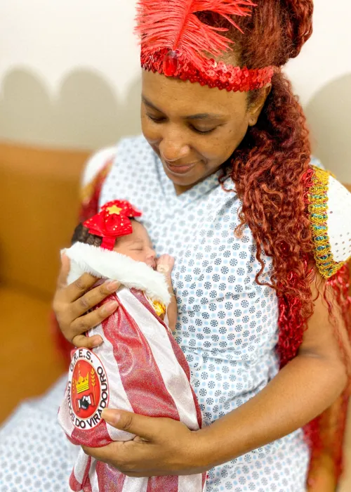 A bebê Júlia Pérola com a mãe Kissila da Silva Aquino homenageiam a escola niteroiense Unidos do Viradouro