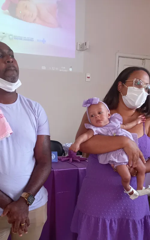 Casal Thaila e Marlon, com Maria Eduarda no colo, dando testemunho no encontro de pais que celebrou o Novembro Roxo