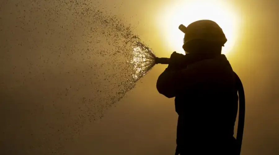 Brigadista faz resfriamento do fogo durante incêndio que atinge o Pantanal
