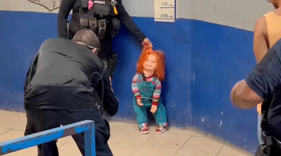 O boneco aparece sendo algemado e fotografado pelos policiais