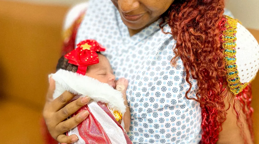 A bebê Júlia Pérola com a mãe Kissila da Silva Aquino homenageiam a escola niteroiense Unidos do Viradouro