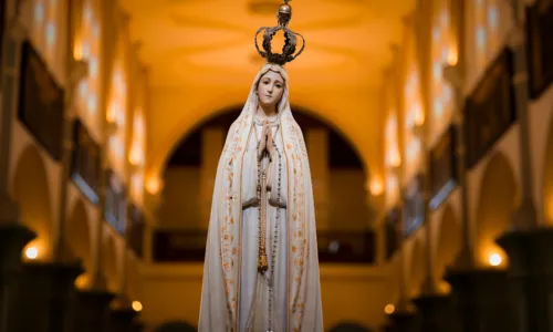 A imagem de Fátima é marcada pelo manto branco, pelas mãos postas em oração e por uma presença doce, mas firme