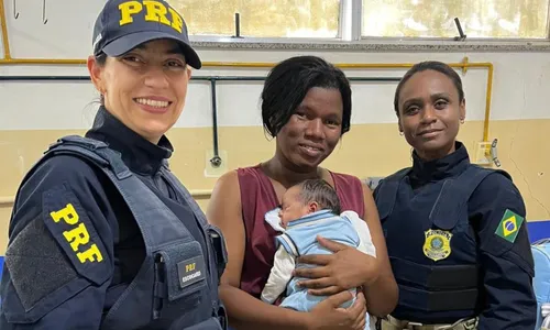 A mãe Gisele segurando o filho Kaíque nos braços, ao lado das agentes da PRF
