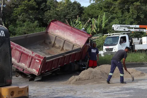 A carga de areia ficou espalhada na pista