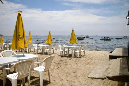 Mesas colocadas na areia do lado esquerdo da praia