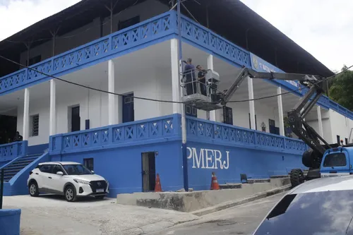 Operários retocam a pintura da fachada do novo batalhão