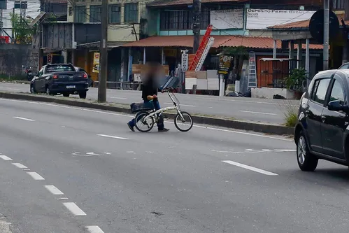 Pessoas atravessam até com bicicleta