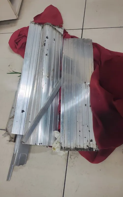 Partes do portão furtado pelos indivíduos e o pano vermelho que estava enrolado nos objetos