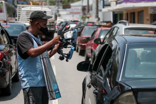 Trabalhadores ganham a vida como podem em sinais pela cidade.