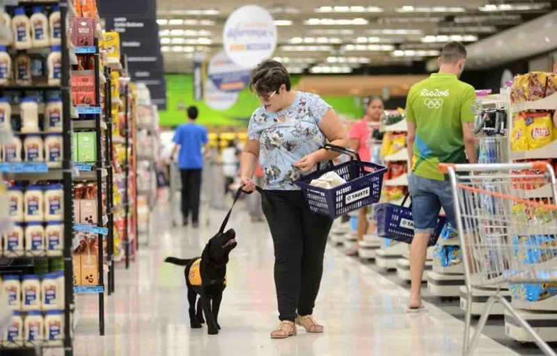 Mulher passeia com seu cachorro dentro de supermercado