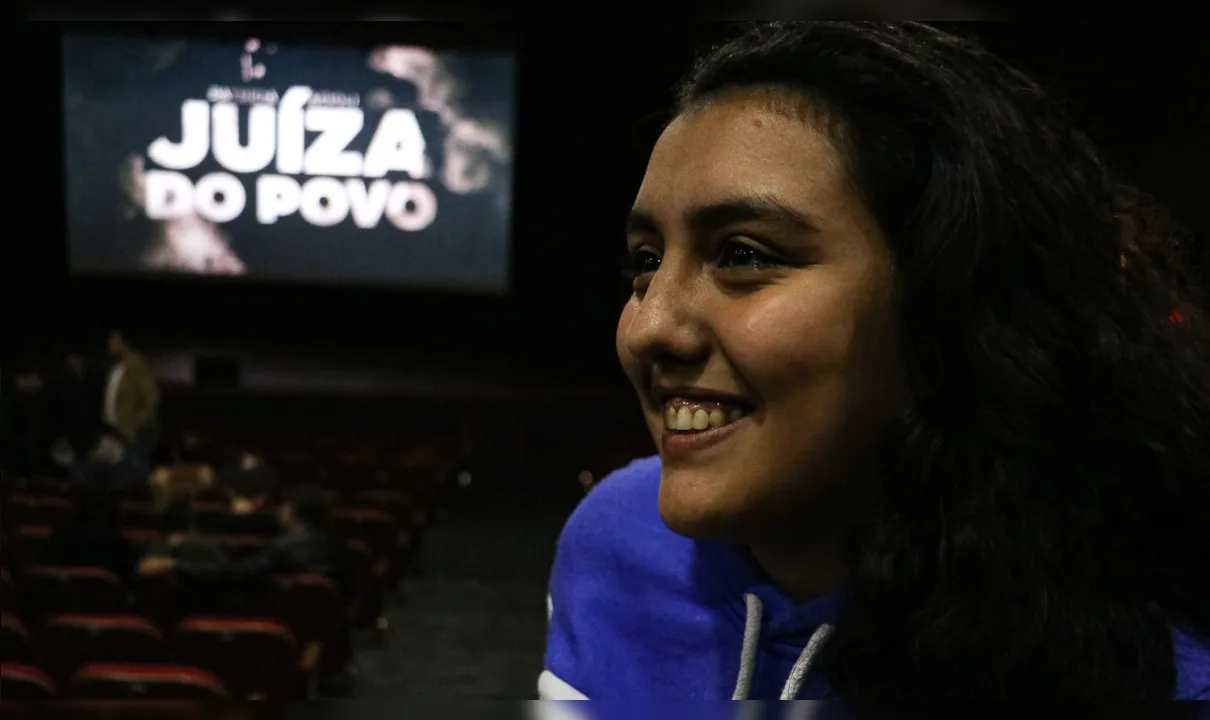 Maria Eduarda Acioli, filha mais nova de Patrícia, assiste ao documentário sobre a mãe