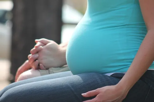 Mulher de mãos dadas durante o período de gravidez