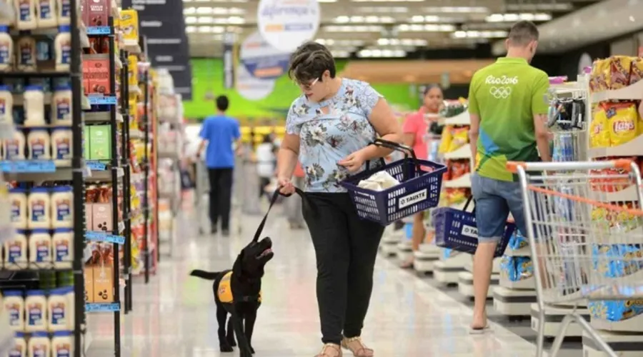 Mulher passeia com seu cachorro dentro de supermercado
