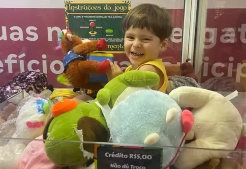 Menino se mantém sorridente dentro da máquina enquanto sua família se preocupa