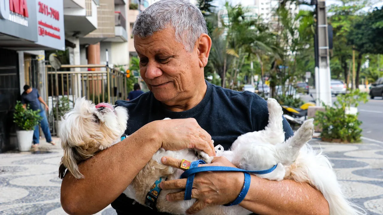 Homem faz carinho em seu cachorro na orla de Icaraí