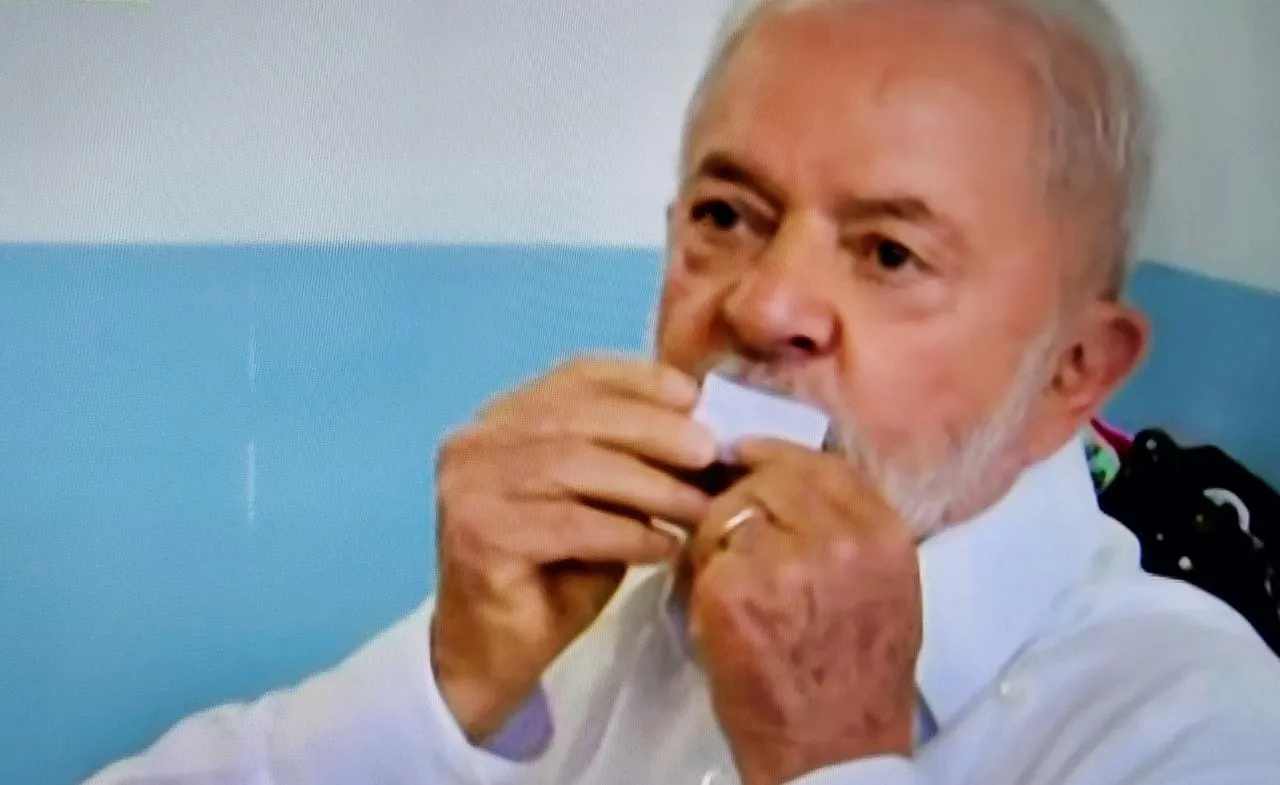 Lula mostra comprovante de votação e o beija