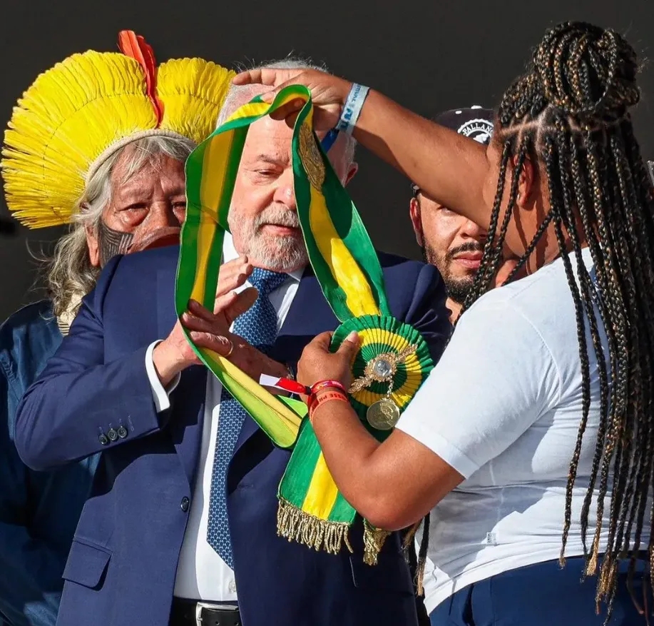Aline Sousa passando a faixa para o presidente Lula