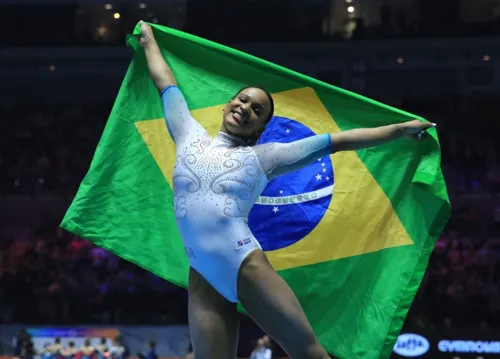 Rebeca Andrade comemora a conquista do título com a bandeira do Brasil