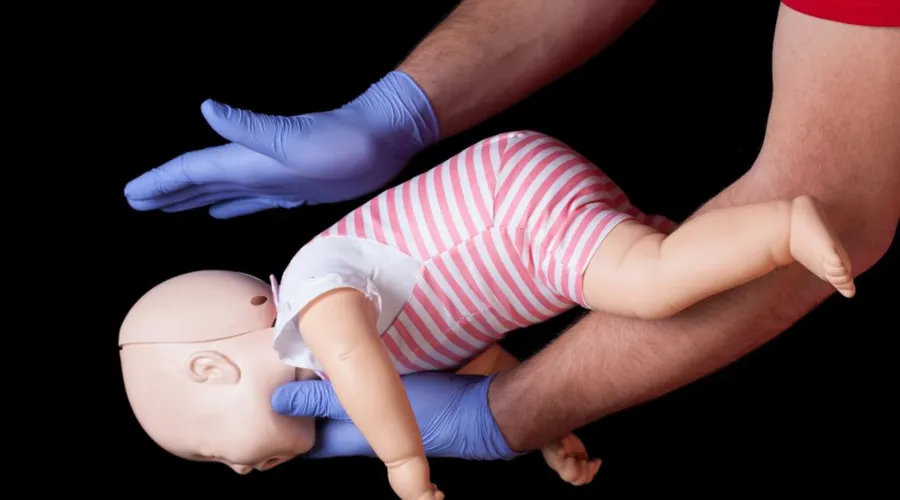 Bebê deve ser colocado de bruços em cima de um braço e receber cinco tapinhas no meio das costas