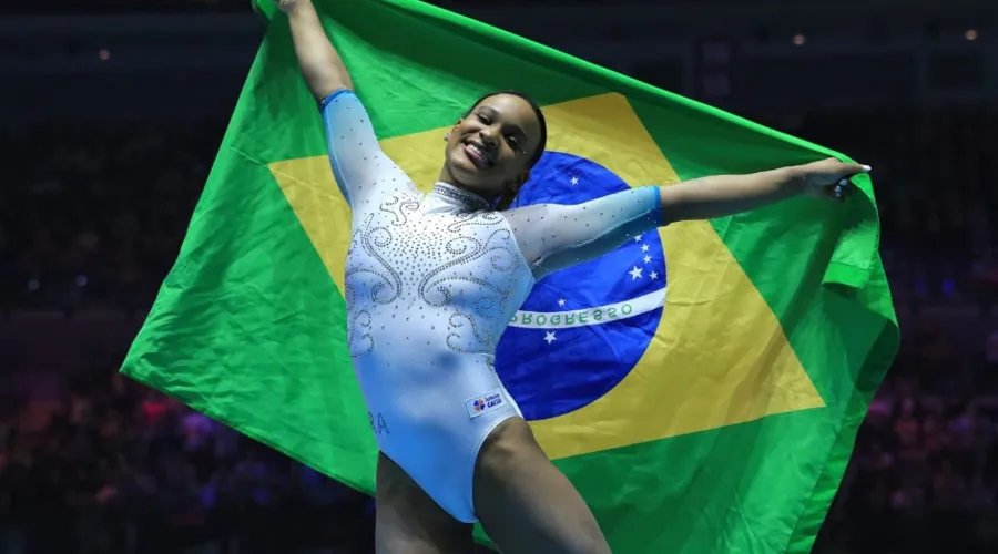 Rebeca Andrade comemora a conquista do título com a bandeira do Brasil