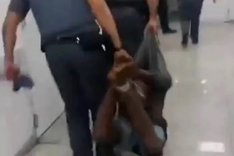 Policiais carregam homem amarrado em São Paulo