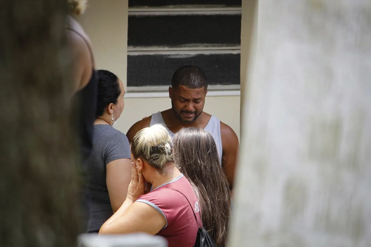 O marido de Juliana e pai de Caio, Erick Pereira, é consolado por parentes e amigos no enterro